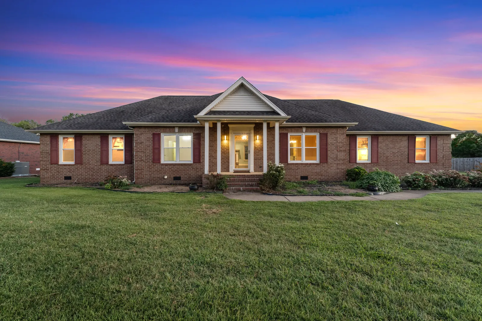 Brick ranch home under a sunset sky