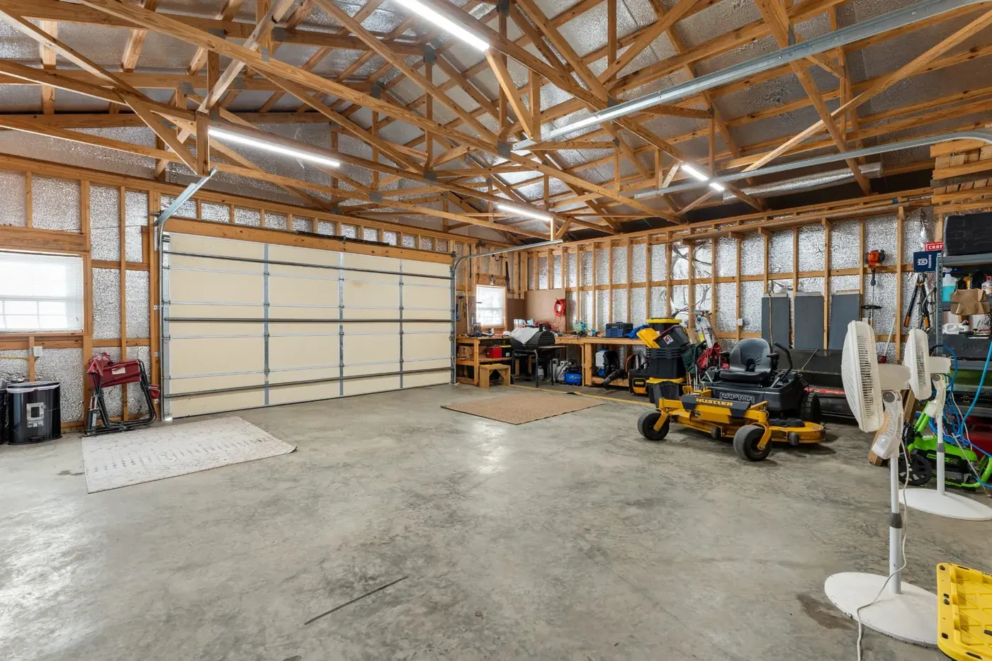 Inside the detached shop, timber trusses over a concrete floor