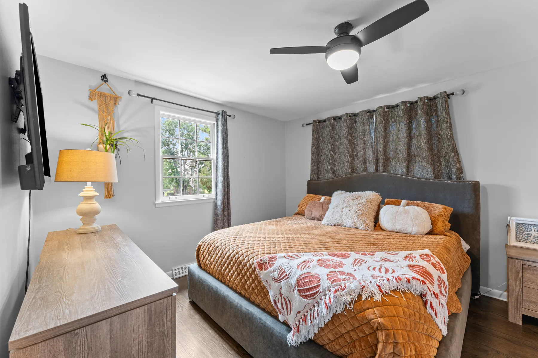 Staged primary bedroom with warm bedding