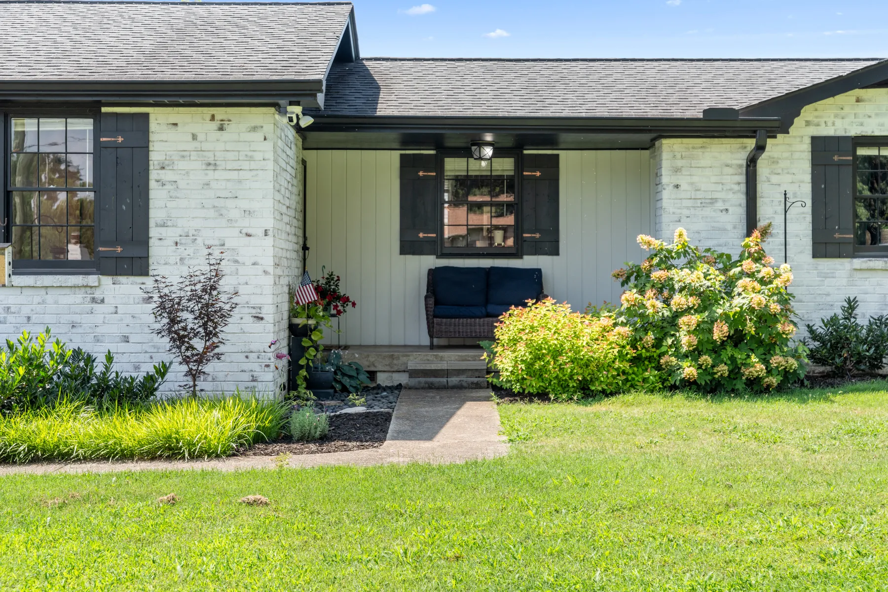 Front of the painted-brick ranch with mature landscaping