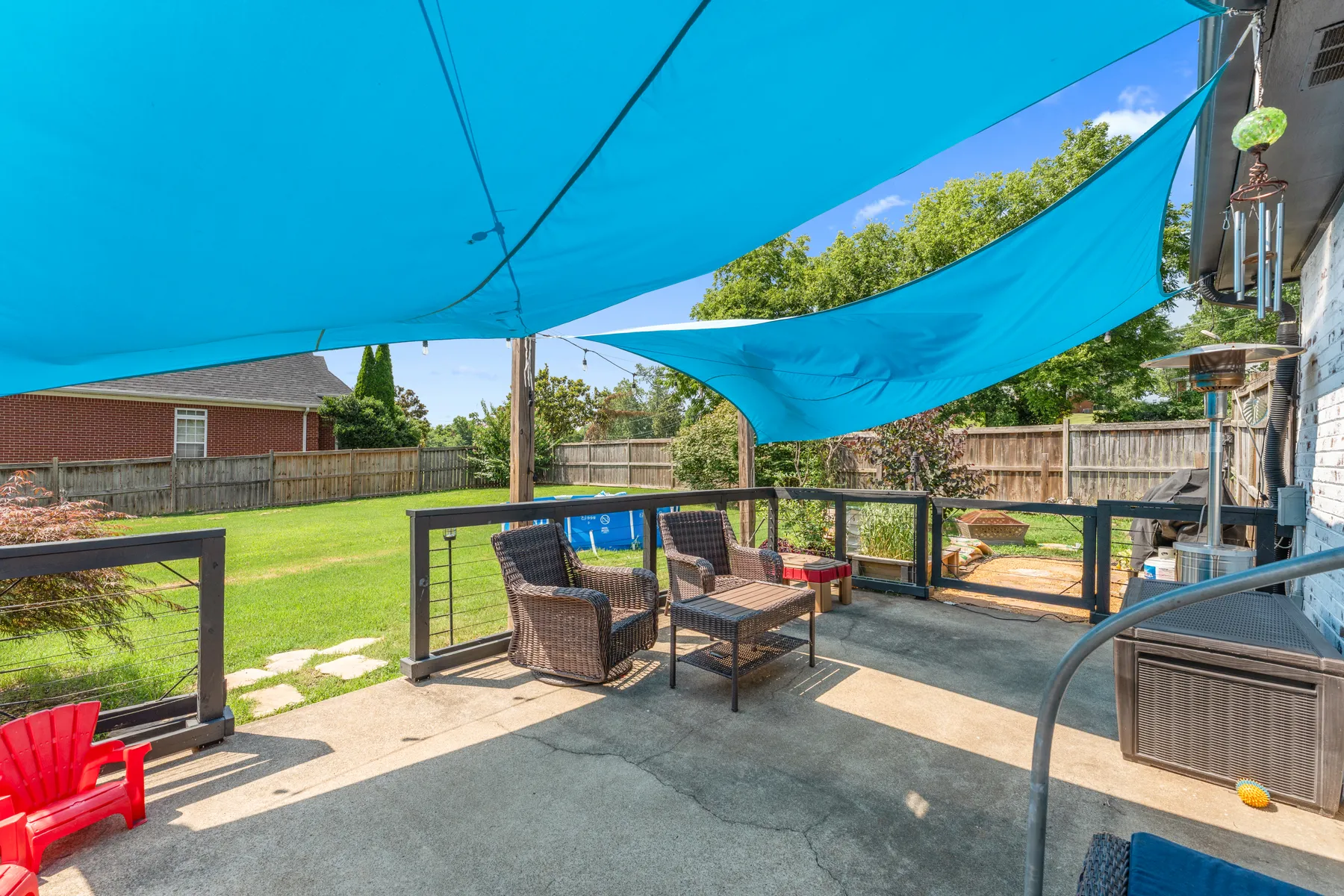 Covered back patio with shade sails and outdoor seating