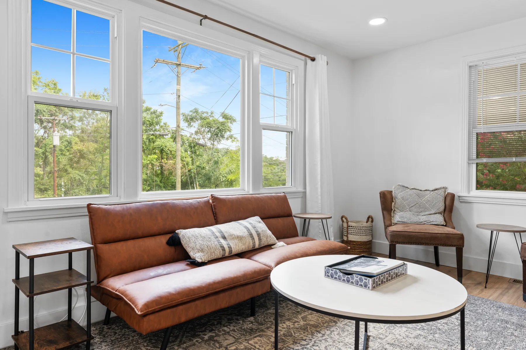Sunlit sitting room with leather seating and bay windows