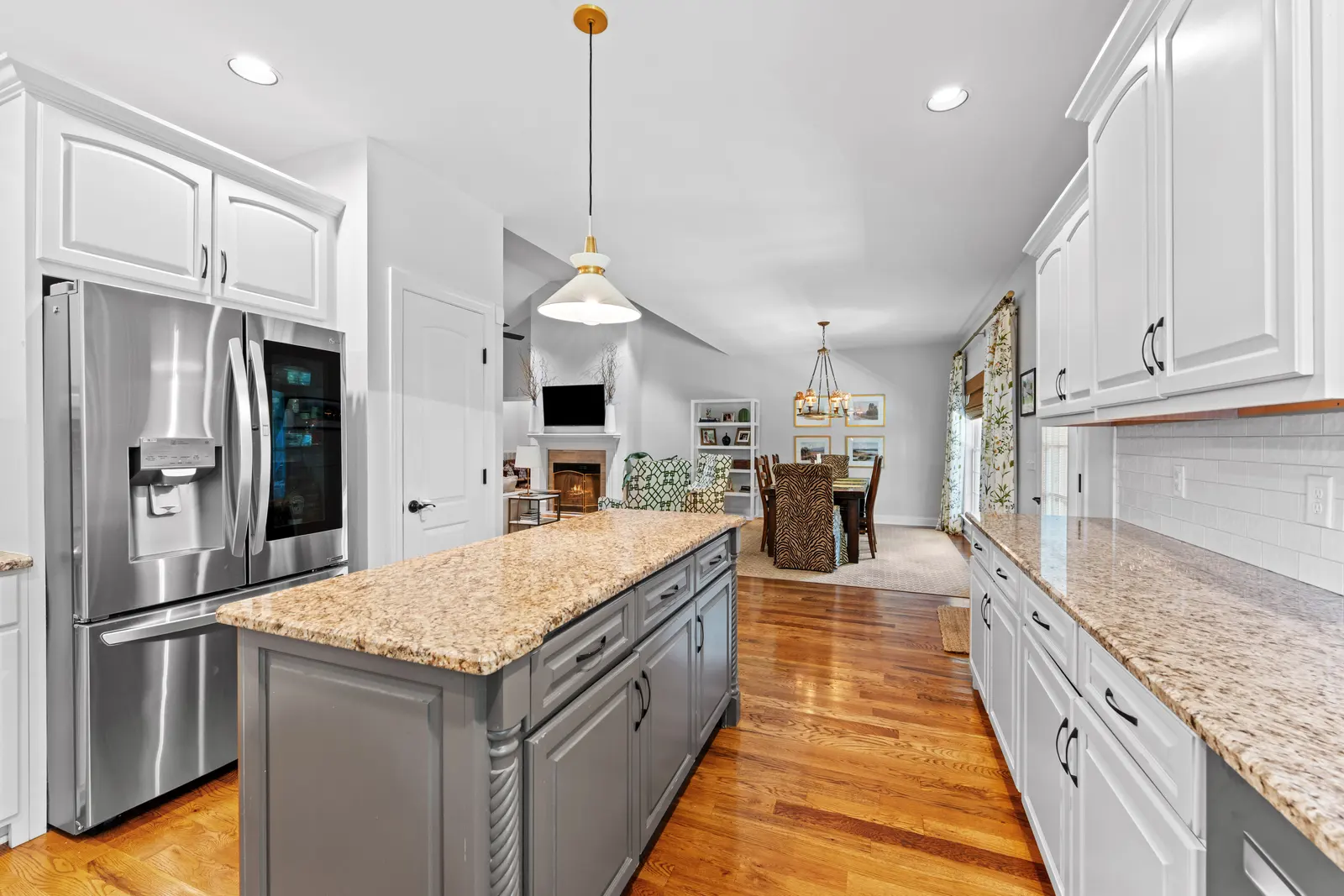 Kitchen with a granite island, custom cabinetry, and stainless appliances