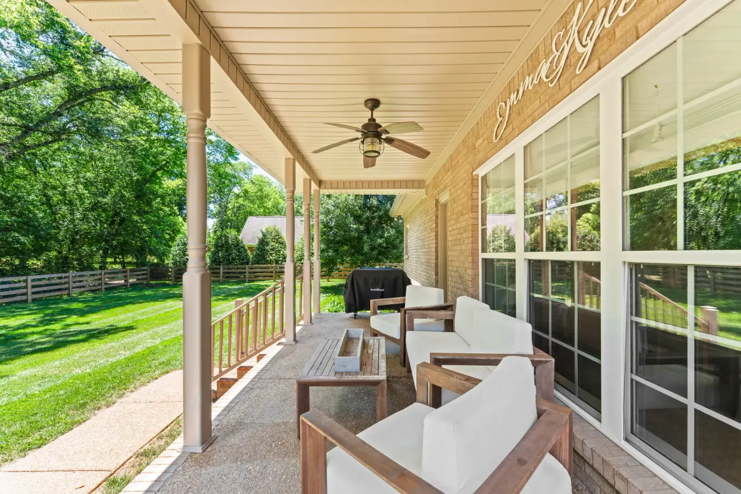 Covered back porch with seating overlooking the lawn