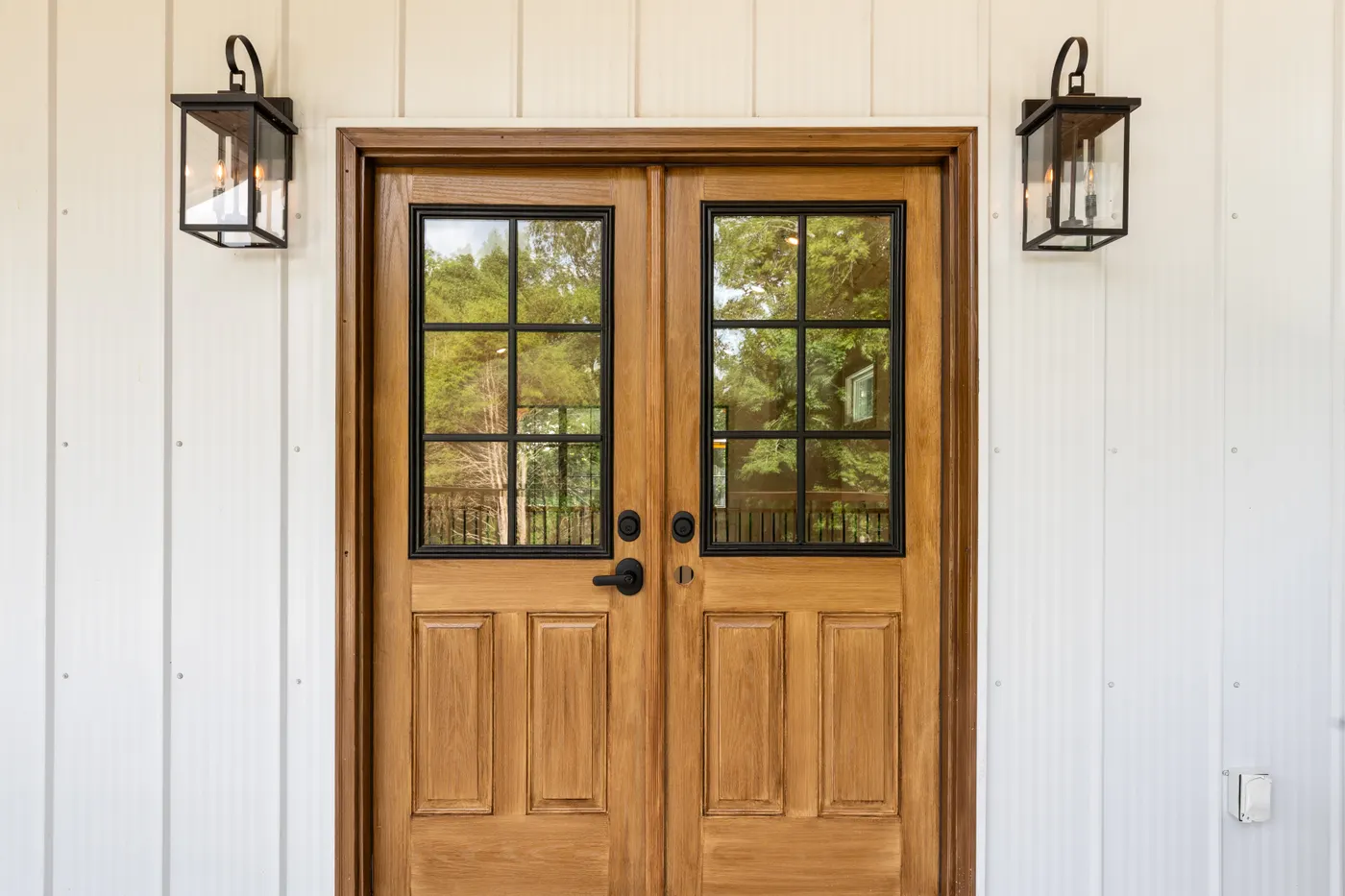 Wood double front door with lantern sconces on a Middle Tennessee home