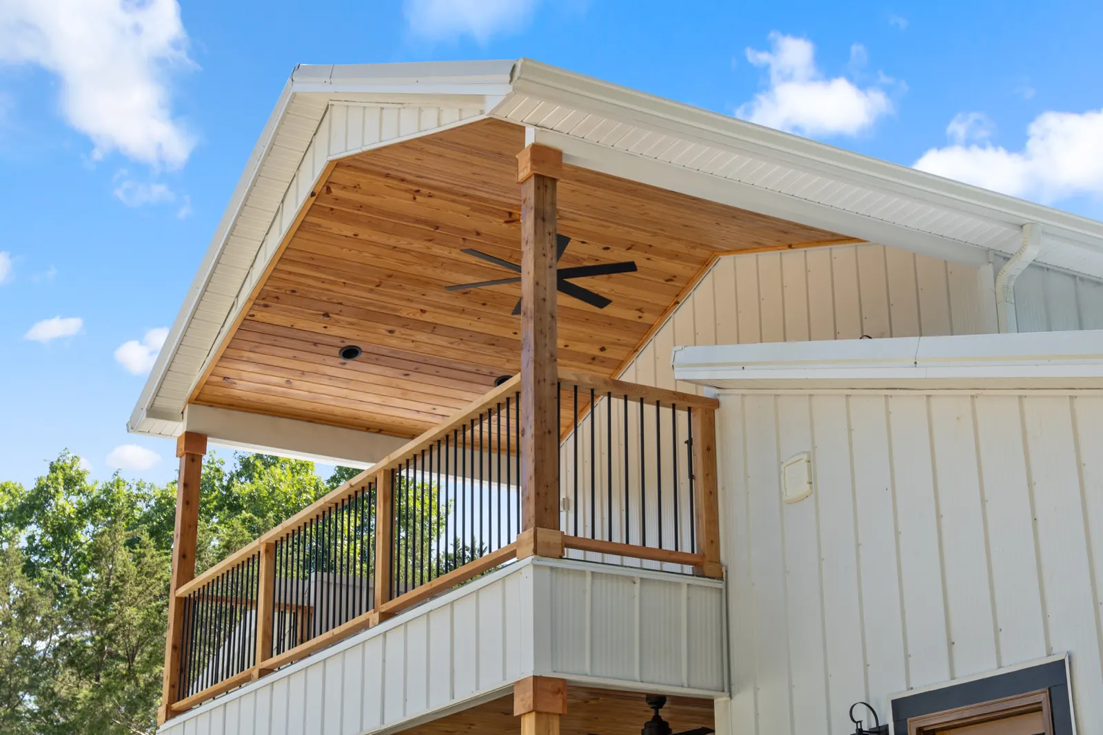 Timber porch columns against the white board-and-batten exterior